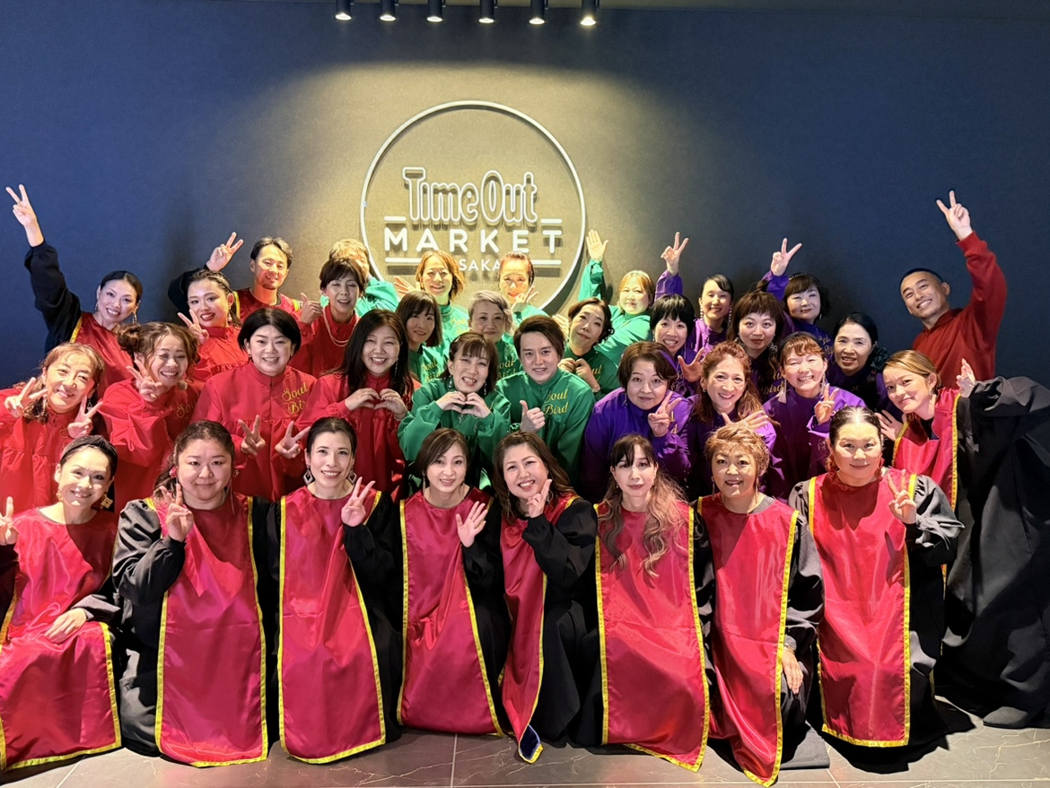 タイムアウトマーケット大阪で行われたクリスマスゴスペルライブ終了後、看板前で撮影したソウルバードクワイアの集合写真
